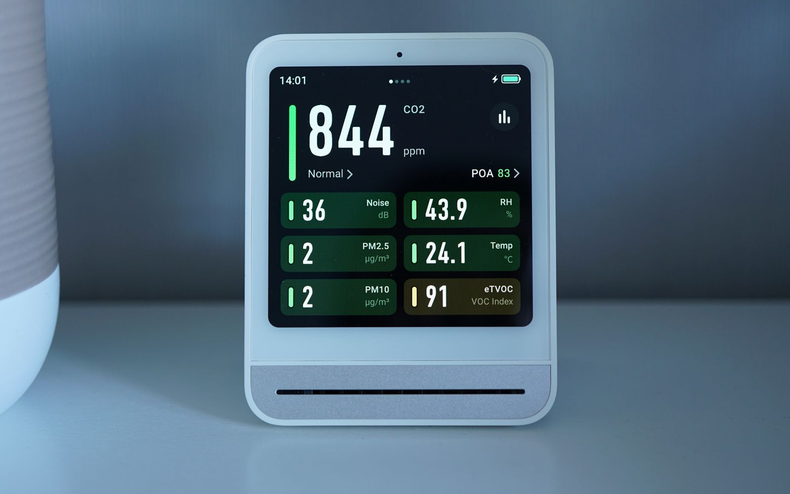 Modern indoor air-quality monitor displaying several environmental readings