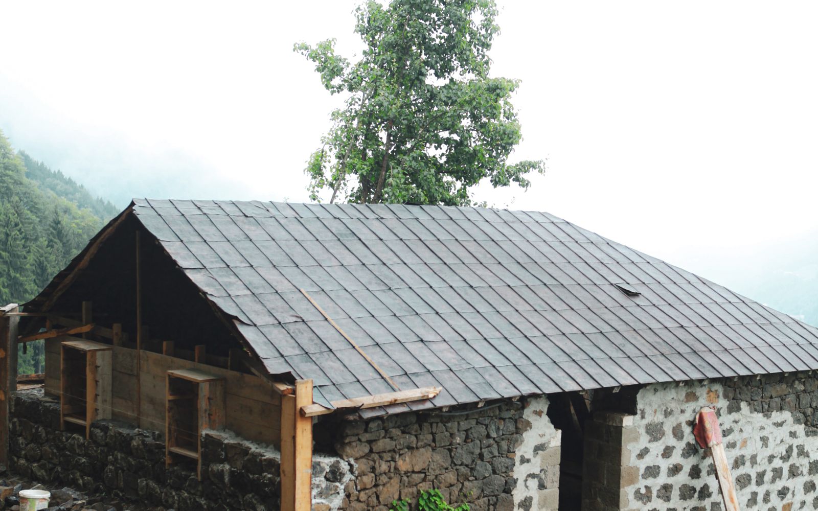 Rustic house under construction with its raised stone foundation visible