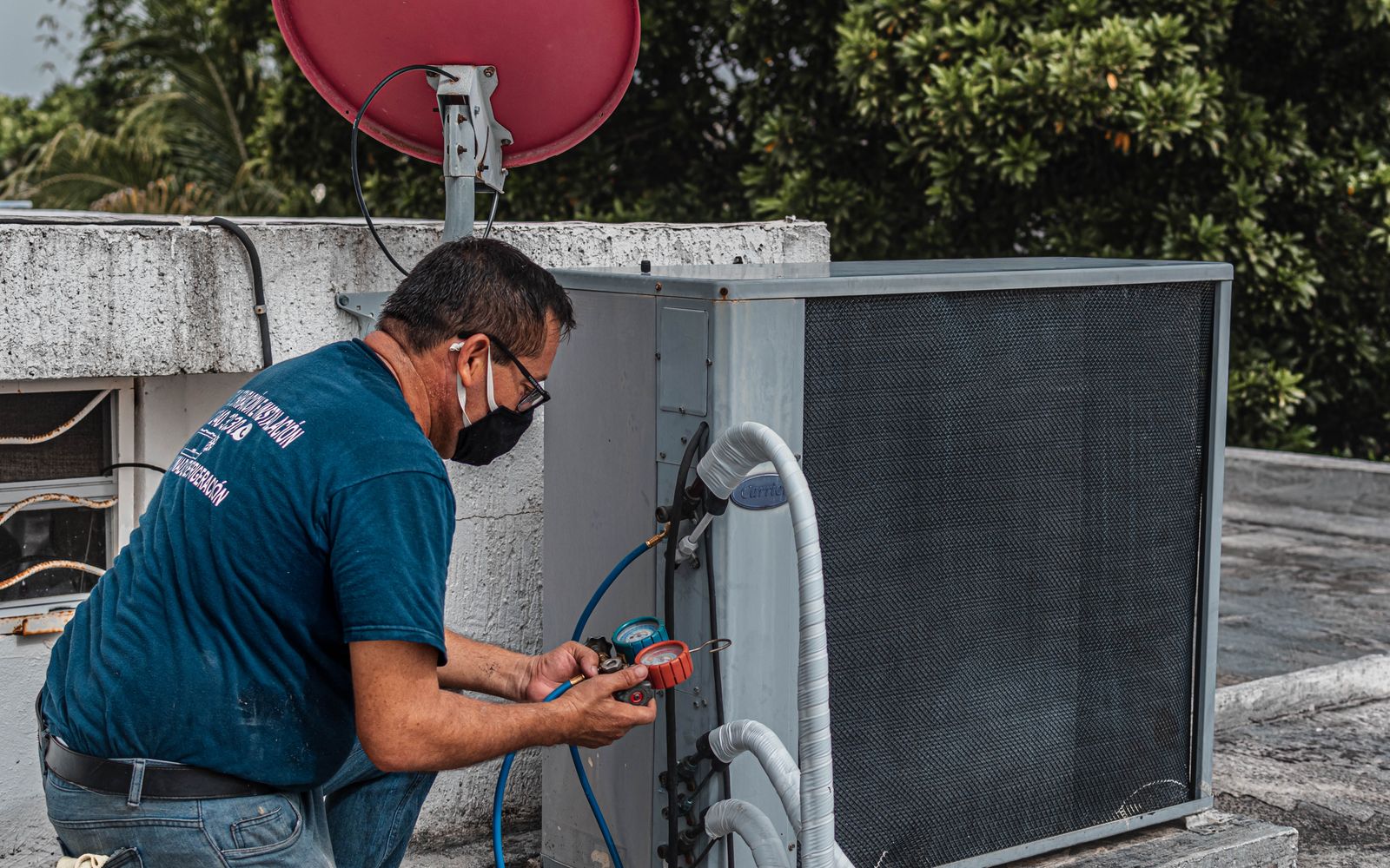 HVAC technician checking pressures and connections on a cooling unit