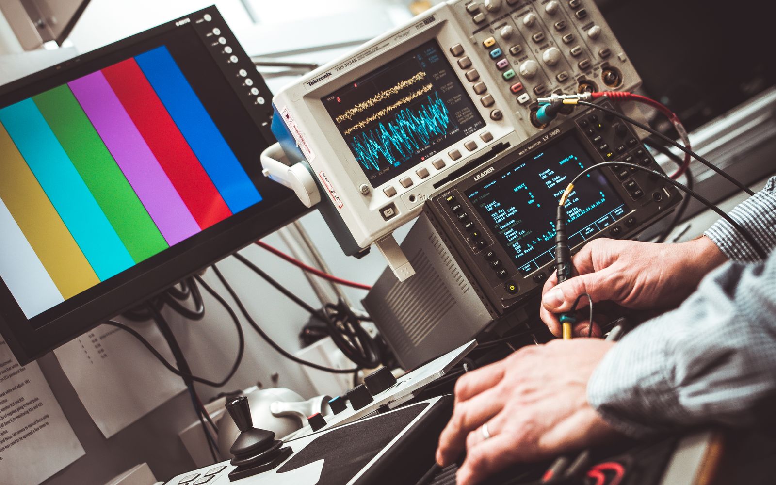 Technician using electronic diagnostic equipment on a workbench