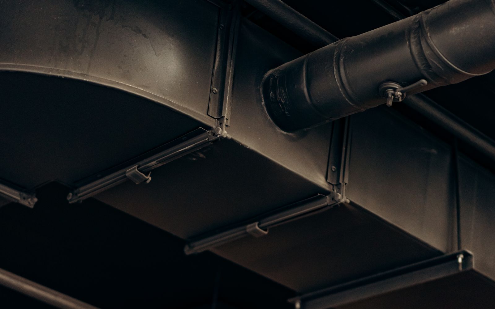 Large metal air ducts crossing the ceiling of a finished interior