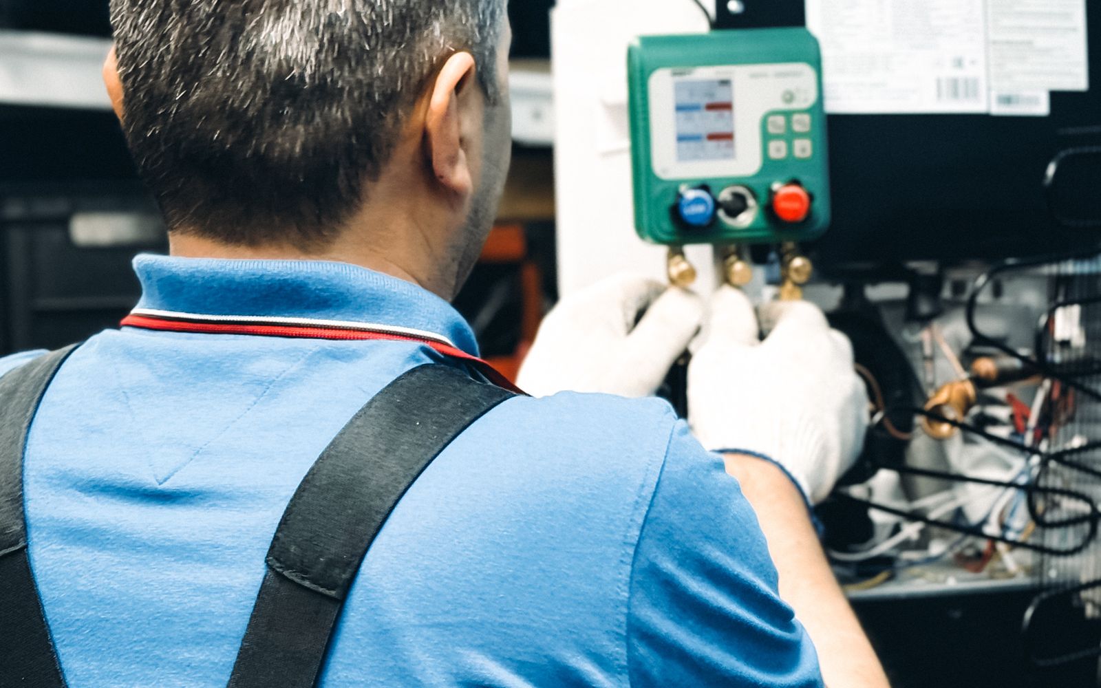 Technician servicing climate-control equipment at a workbench