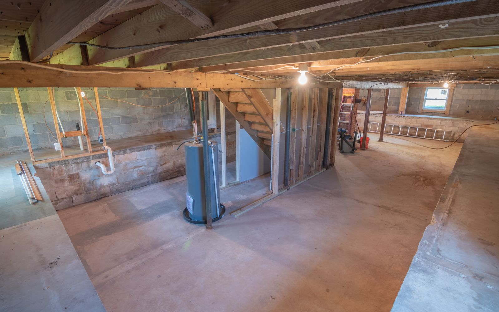 Unfinished basement utility area with exposed framing and plumbing